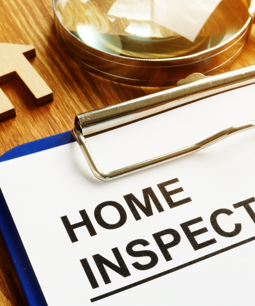 A clipboard with the words home inspection next to a magnifying glass