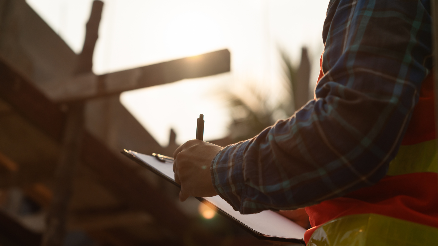 A construction worker writing on a piece of paper